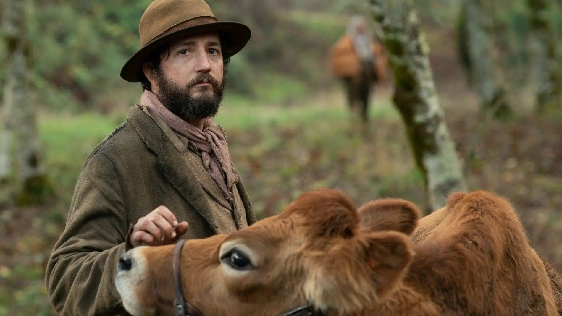 Imagen promocional de la película 'First cow', con el actor John Magaro y la vaca protagonista de la cinta