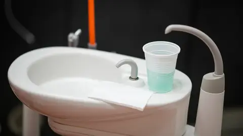 Un vaso con un colutorio en una clínica dental.