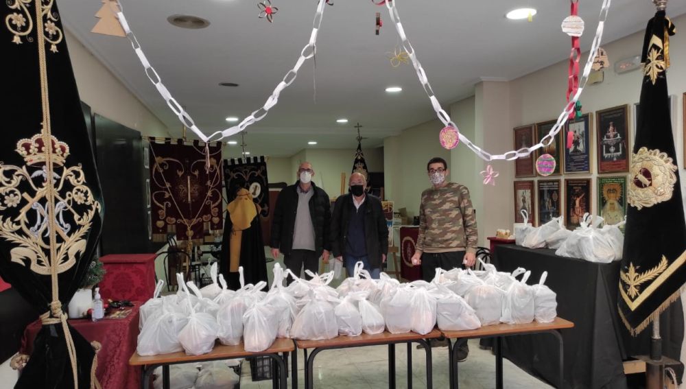 Miembros de la Hermandad de la Flagelación y Gloria de Elche junto a menús listos para su reparto.