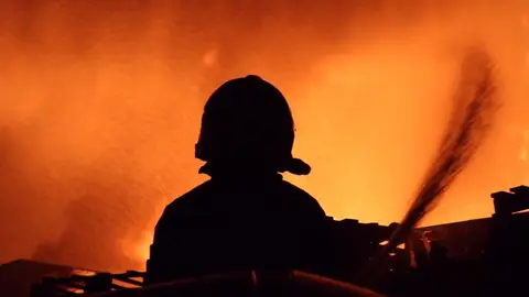 Un bombero trabaja en un incendio Un bombero trabaja en un incendio