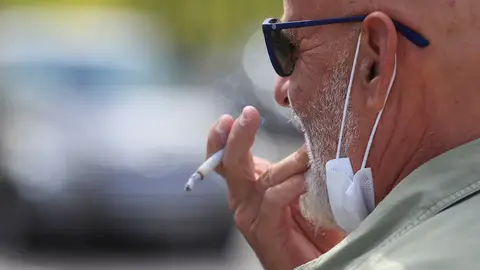 Un hombre fuma en la calle