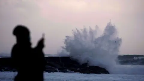 Las olas rompen con fuerza contra las rocas de la costa Las olas rompen con fuerza contra las rocas de la costa