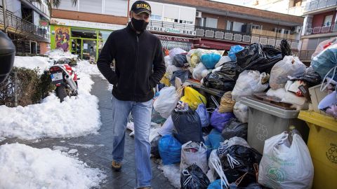 Una persona pasea junto a las bolsas de basura acumuladas en Madrid.