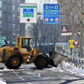 Una excavadora limpia de nieve una calle de Madrid