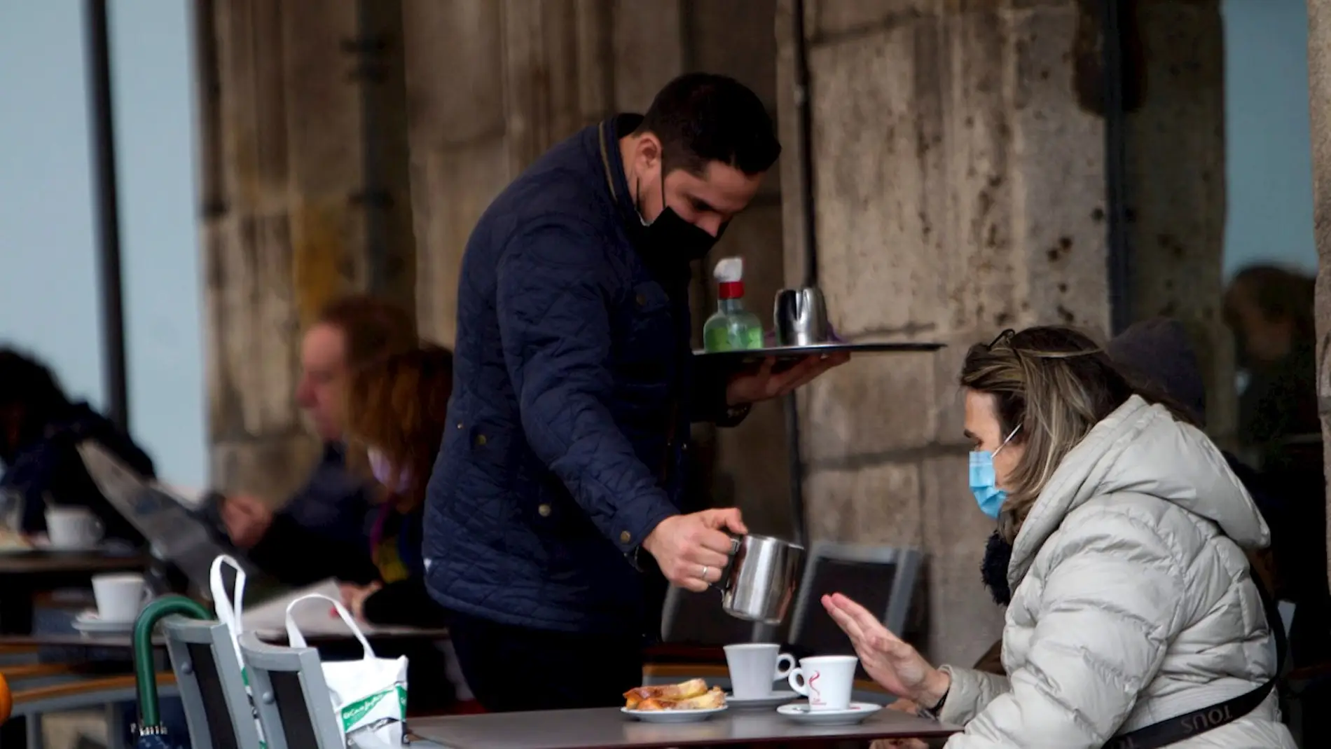 Una mujer toma un café en una terraza en Vigo