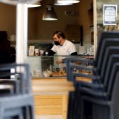 Un hostelero prepara cafés para llevar en una cafetería 