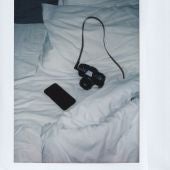 Una cámara de fotos y un móvil en una cama