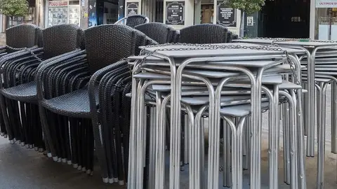 Sillas y mesas apiladas en la céntrica calle Carretería de Cuenca a la espera de poder abrir y montar la terraza Sillas y mesas apiladas en la céntrica calle Carretería de Cuenca a la espera de poder abrir y montar la terraza