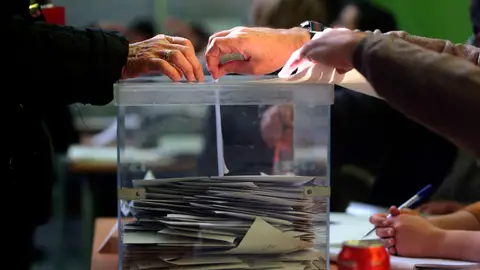 Un votante deposita su voto en la urna en una jornada electoral