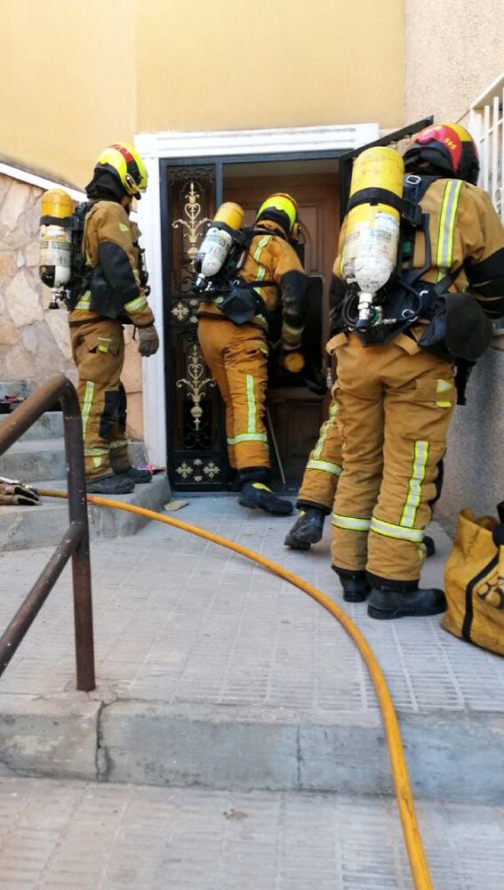 Efectivos de bomberos aperturando la vivienda siniestrada en Crevillent.
