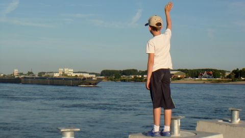 Ni&ntilde;o saludando a un barco