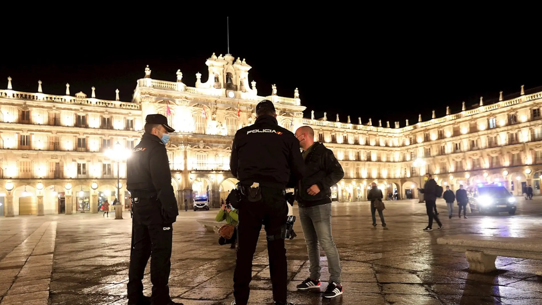 Dos agentes de la Policía Local y Nacional hablan con un ciudadano en la Plaza Mayor de Salamanca