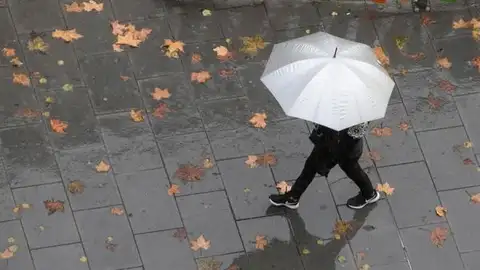 Imagen de archivo de una persona caminando bajo la lluvia Imagen de archivo de una persona caminando bajo la lluvia