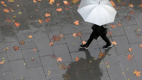Una persona camina bajo la lluvia Una persona camina bajo la lluvia