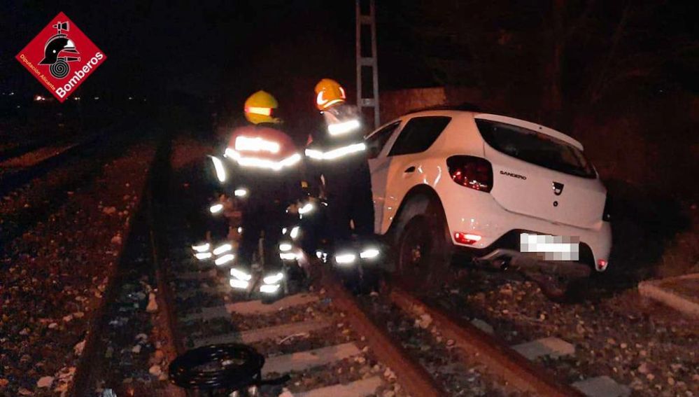 Bomberos en las labores de extracción del coche en el paso a nivel de Villena.