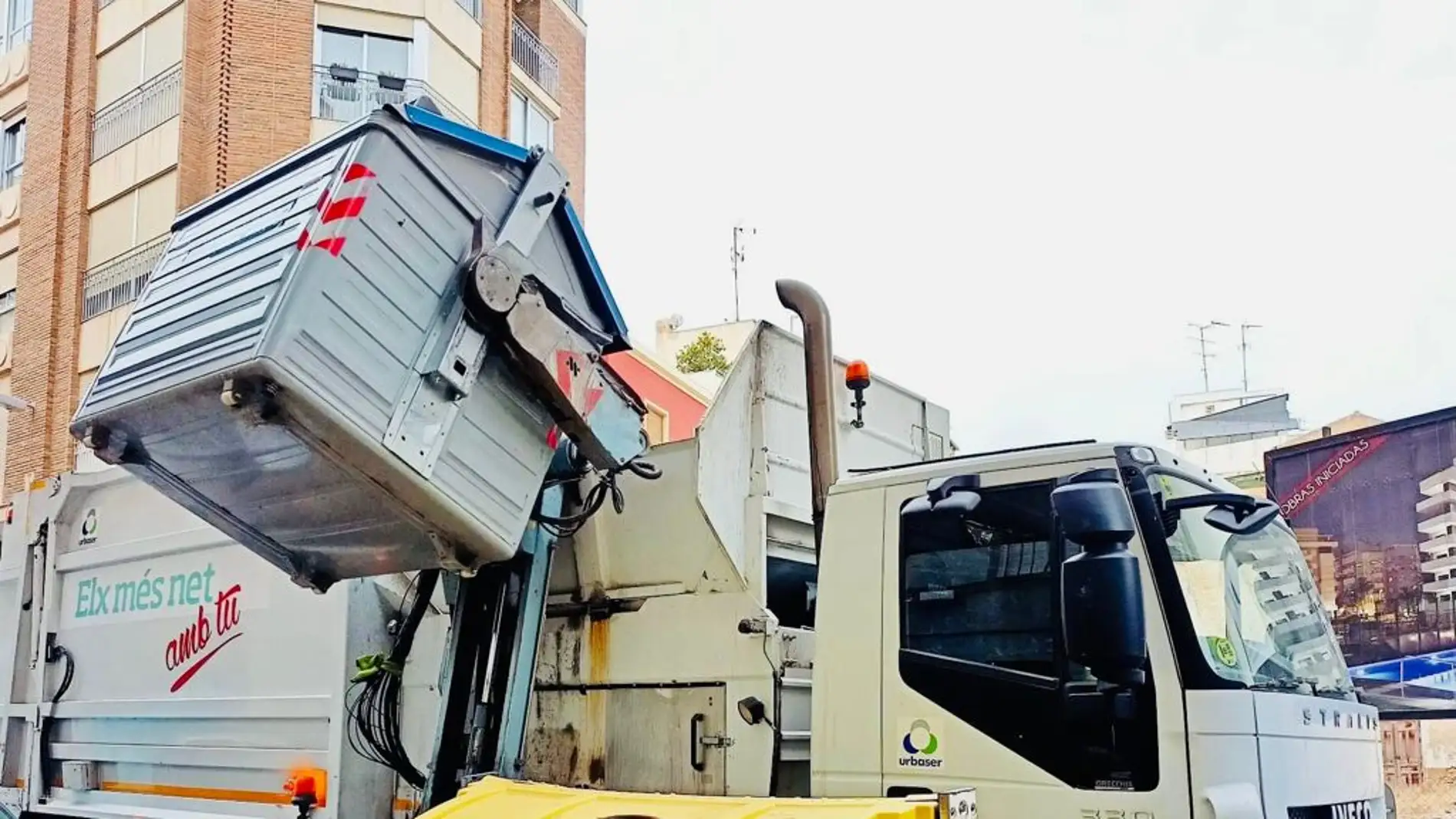 Camión del servicio de limpieza de Elche recoge un contenedor de papel y cartón.