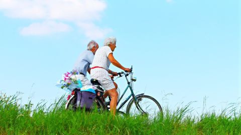 hombre y mujer mayores de 65 años en bicicleta