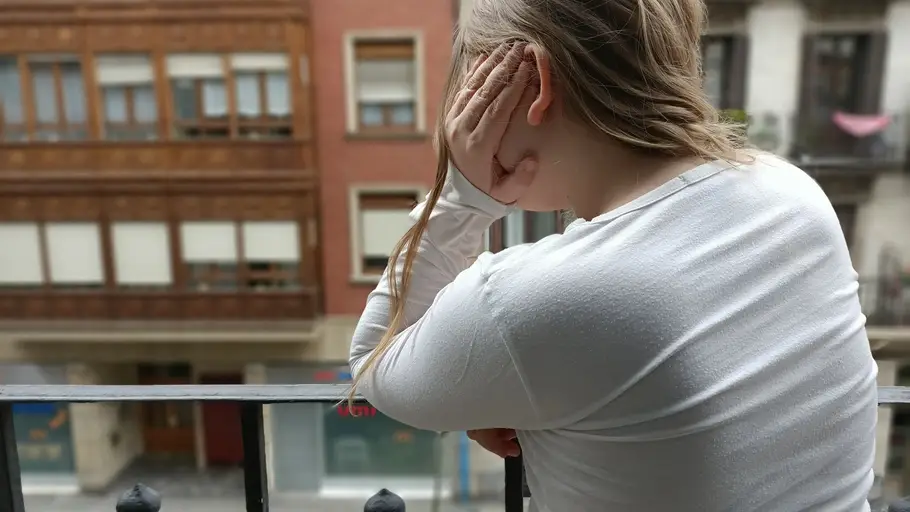 Imagen de una niña asomada al balcón durante el confinamiento por el estado de alerta Aniversario estado de alarma