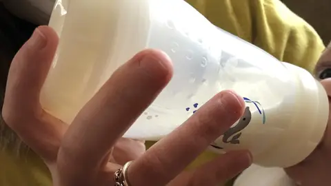 Un bebé toma el biberón Un bebé toma el biberón