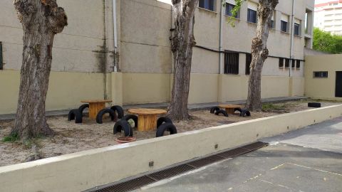 Mesas y sillas realizados con material reciclado en el exterior del colegio