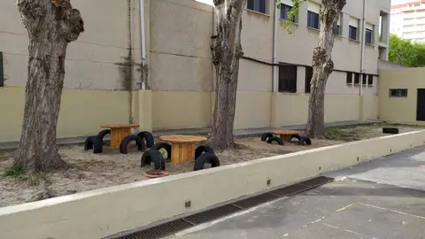 Mesas y sillas realizados con material reciclado en el exterior del colegio Mesas y sillas realizados con material reciclado en el exterior del colegio