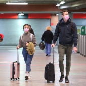 Imagen de archivo de personas con maletas en una estación de tren