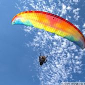 Un usuario disfrutando de las vistas de Menorca mientras vuela con el parapente. 