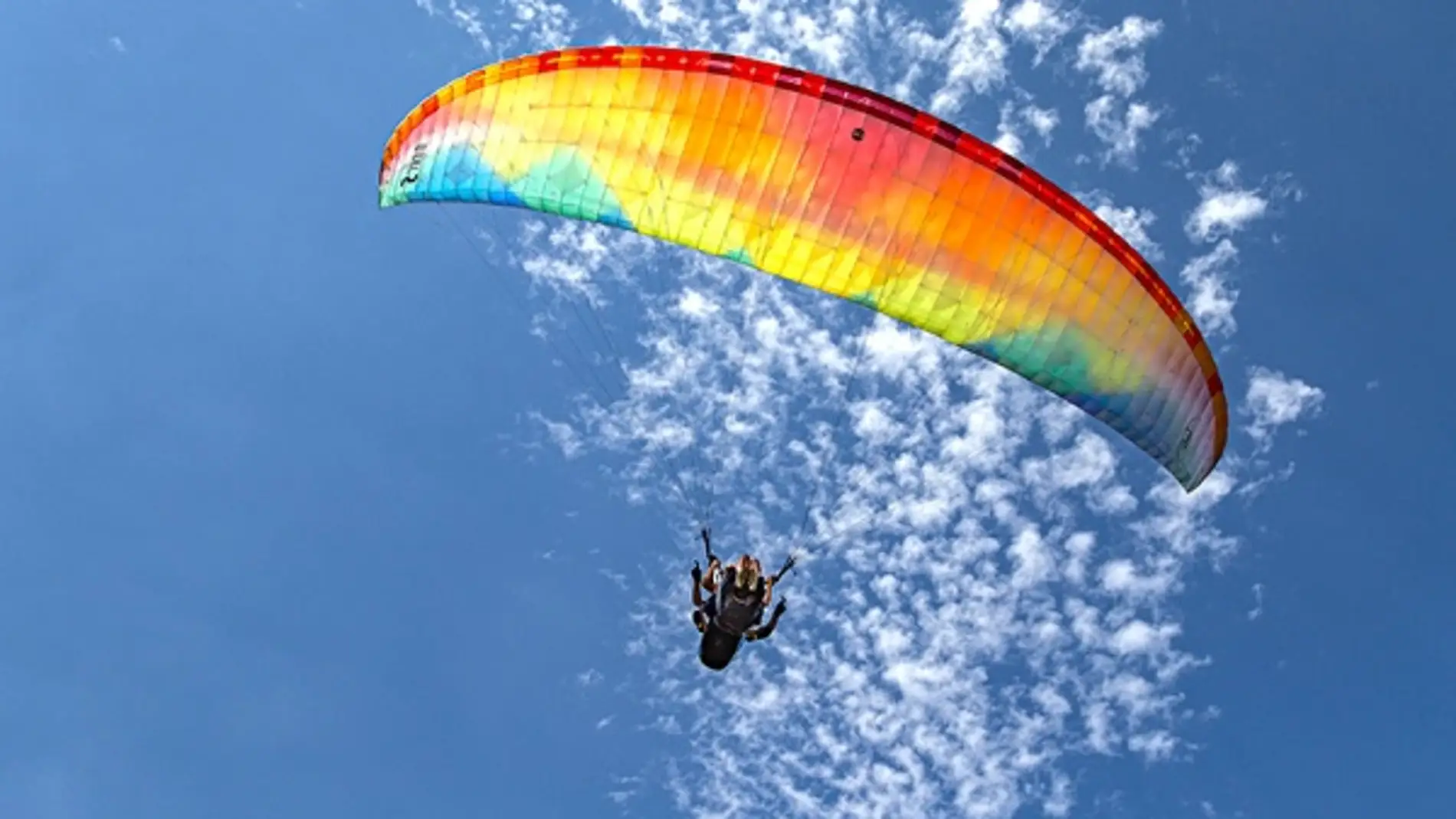 Un usuario disfrutando de las vistas de Menorca mientras vuela con el parapente. 