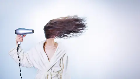 mujer secándose el pelo con mucha intensidad mujer secándose el pelo con mucha intensidad