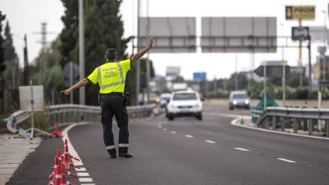 Un agente de la Guardia Civil de Tr&aacute;fico da el alto a un conductor