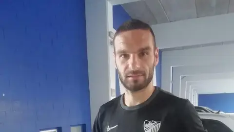 David Lombán muestra una camiseta del Málaga CF firmada por la plantilla Sorteo solidario TripleA