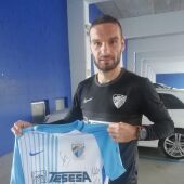 David Lombán muestra una camiseta del Málaga CF firmada por la plantilla