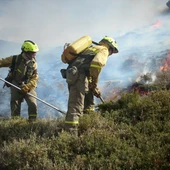 Dos trabajadores en tareas de extinción de un incendio forestal Dos trabajadores en tareas de extinción de un incendio forestal