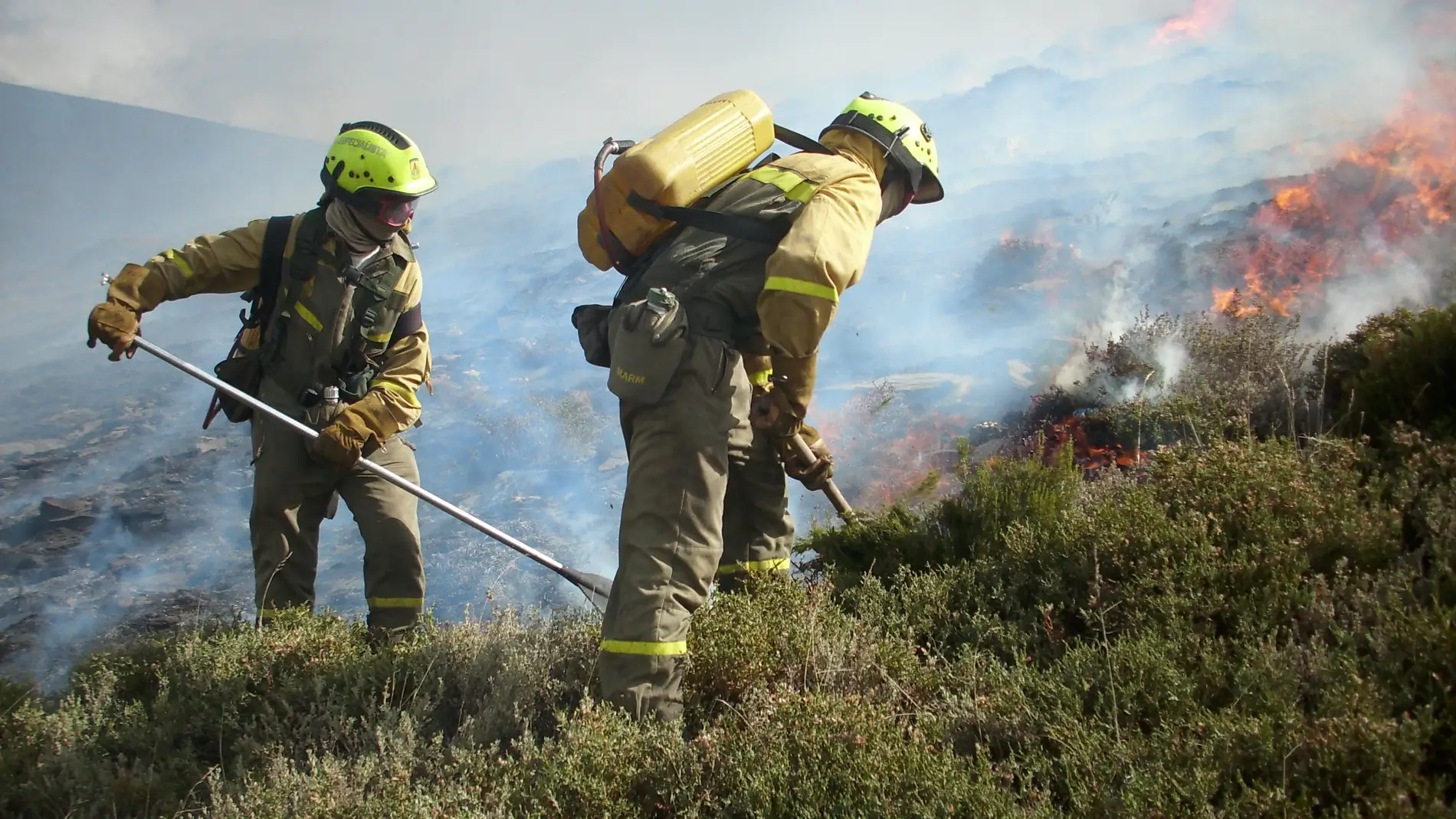 Dos trabajadores en tareas de extinción de un incendio forestal