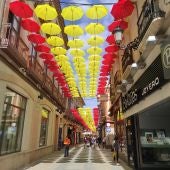 Imagen de la calle de las Escuelas (Valdepeñas) adornada con paraguas