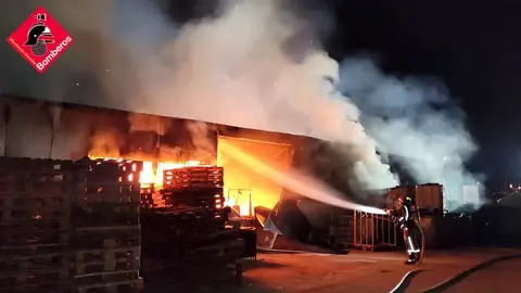 Un bomberos en el incendio de la fábrica de palets de Elche. Un bomberos en el incendio de la fábrica de palets de Elche.