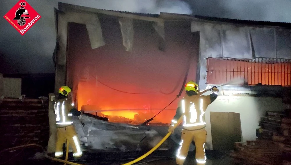 Bomberos en las labores de extinción del incendio de la fábrica de palets de Elche.