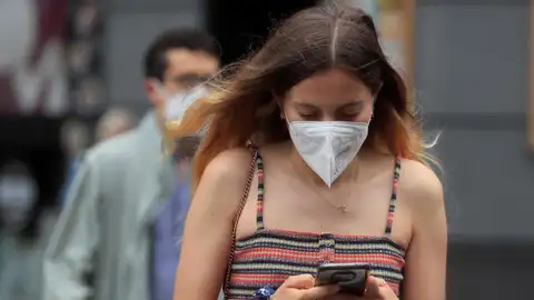 Una joven con mascarilla camina por Madrid Una joven con mascarilla camina por Madrid