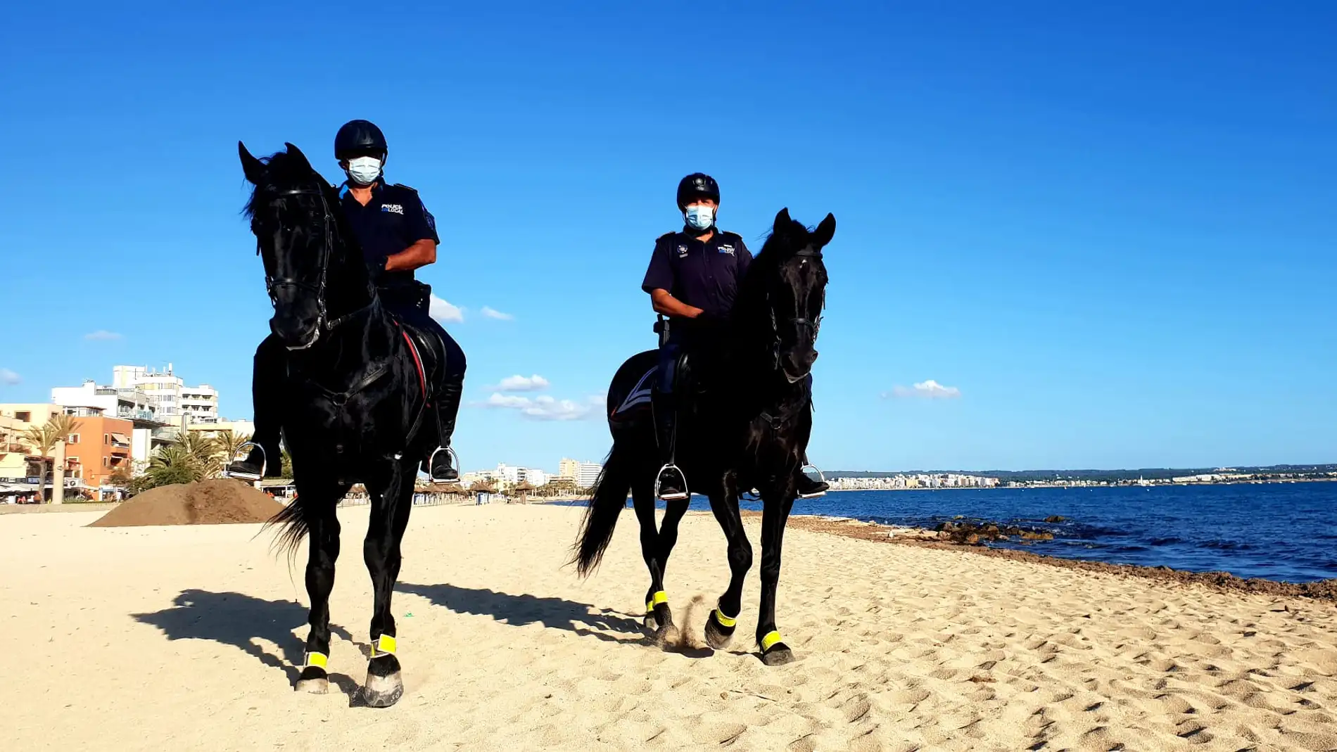 Agentes de la unidad de la policía montada de Palma patrullan las playas de la ciudad durante la revetla de Sant Joan.
