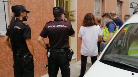 Agentes de la Policía Nacional con una de las personas detenidas en Elche. Agentes de la Policía Nacional con una de las personas detenidas en Elche.
