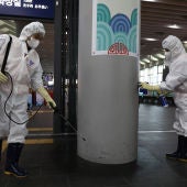 Dos trabajadores desinfectan las instalaciones del transporte público en Wuhan, en China.