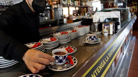 Un hostelero sirve un caf&eacute; en un bar de Galicia