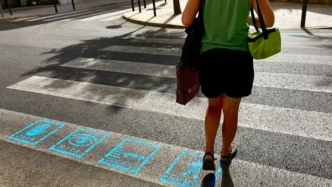 Una persona cruza un paso de peatones con pictogramas en Elche. Una persona cruza un paso de peatones con pictogramas en Elche.