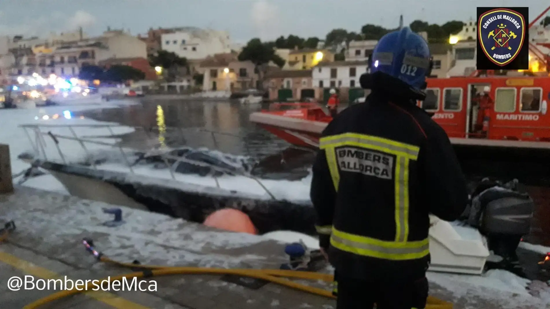 Un bombero frente a la embarcación incendiada en Portopetro, que ha obligado a activar el plan anticontaminación 