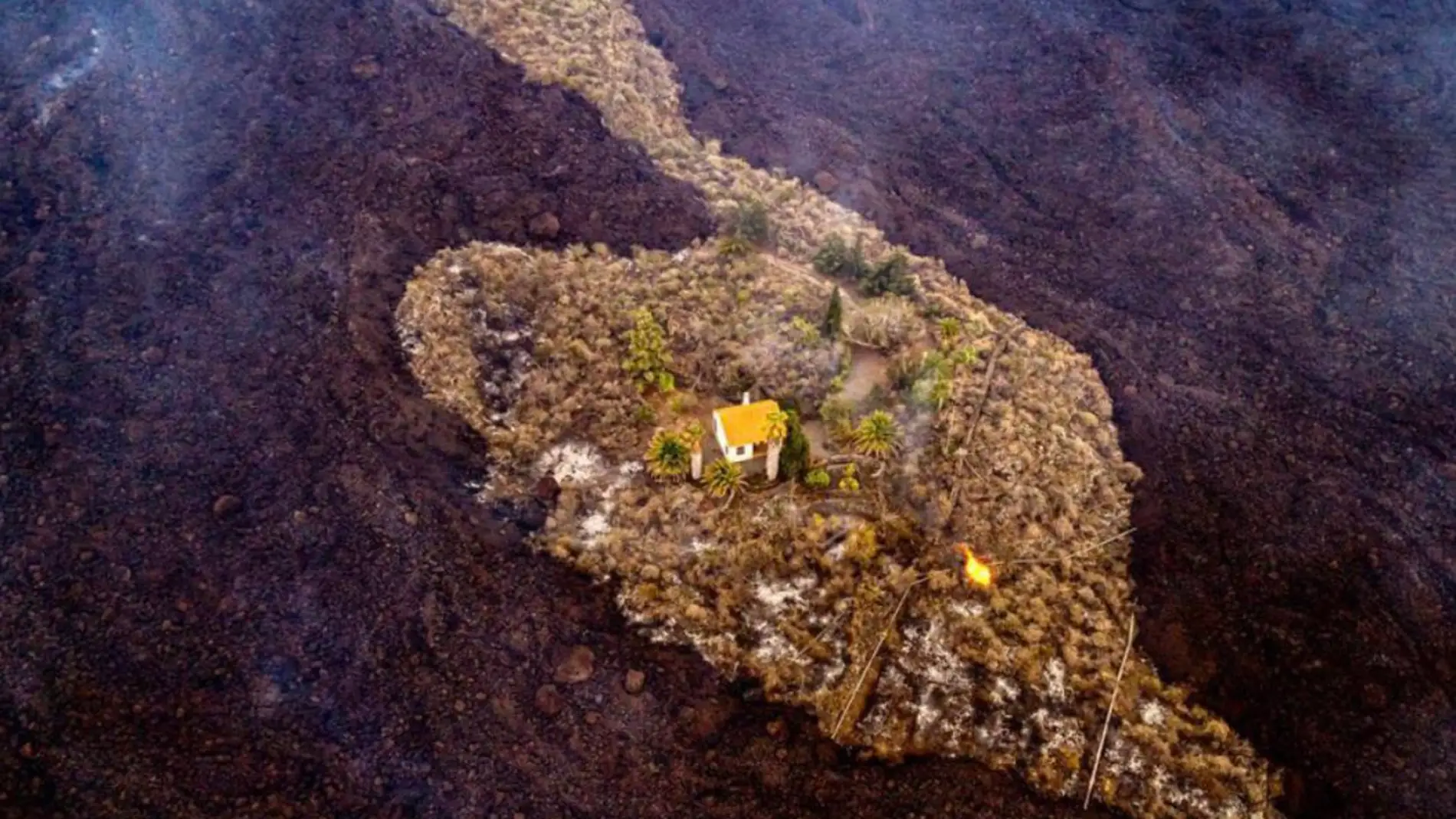 La impactante imagen de una casa rodeada de la lava del volcán de La Palma