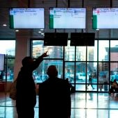 Varios usuarios de Renfe esperan n el vestíbulo de la estación de Sants a que aparezca información sobre los horarios de los trenes.