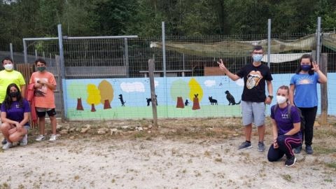 Los j&oacute;venes voluntarios junto a su obra