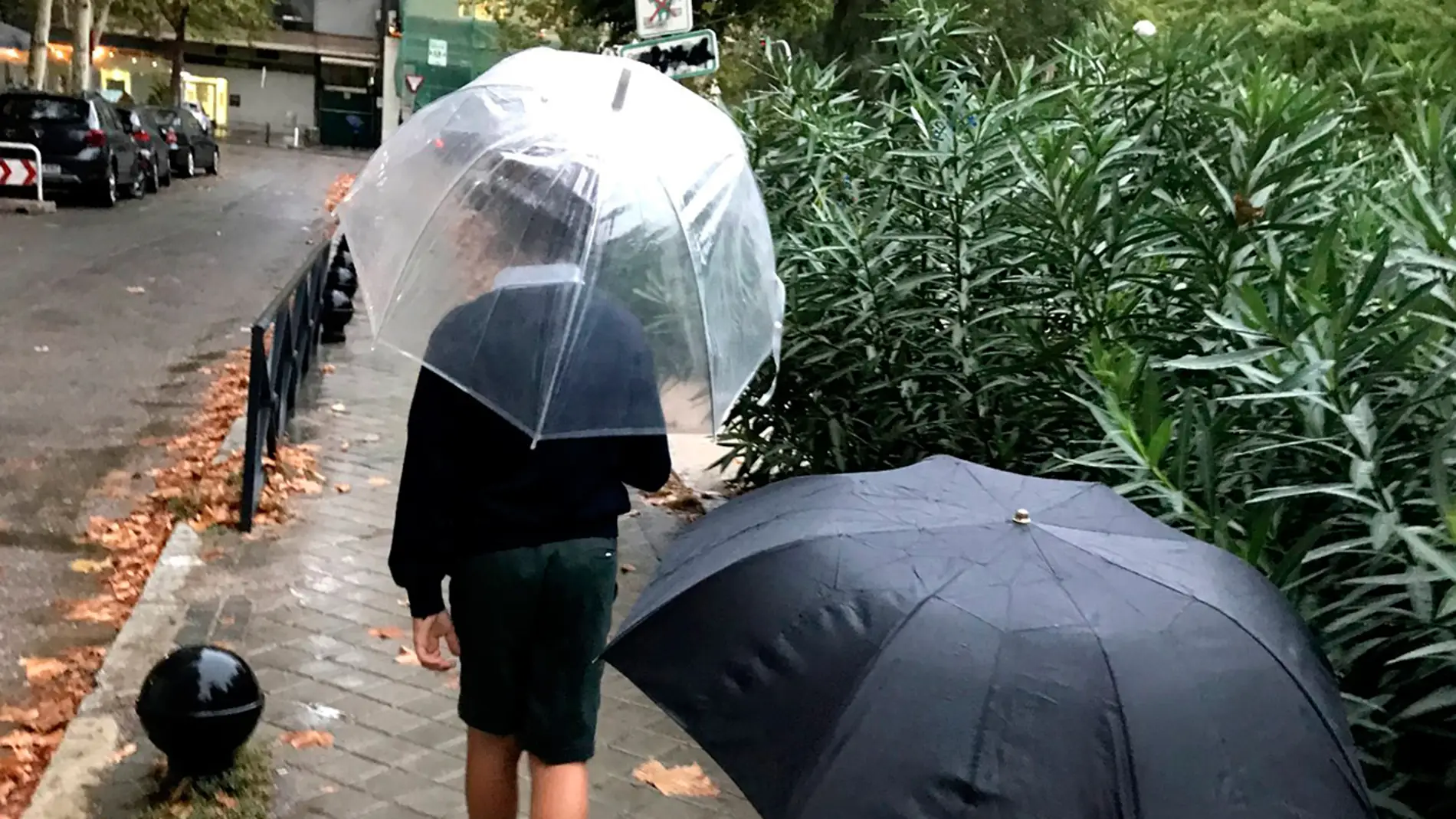 Niños caminando con paraguas 
