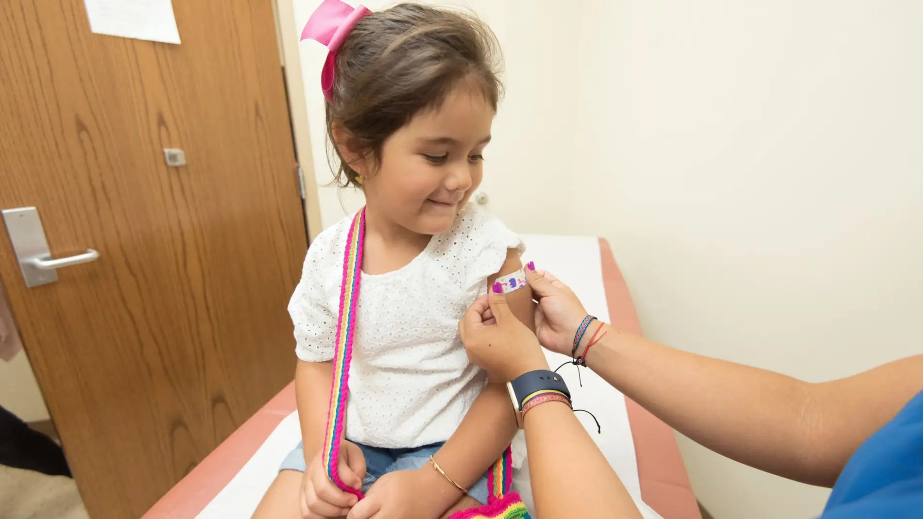 Enfermera pone una vacuna a una niña pequeña