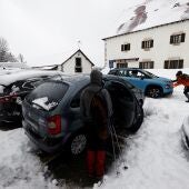 Un conductor entra a su vehículo en una zona afectada por las nevadas.